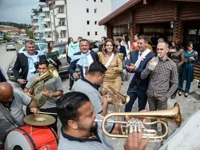 Svatovi ispred restorana sa trubačima Svatovi se okupili oko trubača ispred restorana u kome se pravi svadba